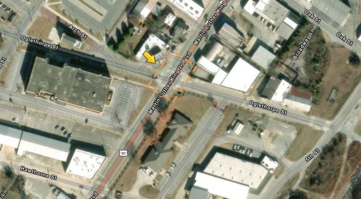 Aerial map depicting the intersection of Martin Luther King Jr Blvd and Oglethorpe St, with an orange arrow pointing to a specific spot near the crossroads. Surrounding buildings and streets are clearly visible.